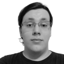 Monochromatic photo of a caucasian male in his early twenties, slightly overweight, shoulder-length hair tied at the back, wearing slightly crooked square-framed glasses and a black T-shirt upon an empty background
